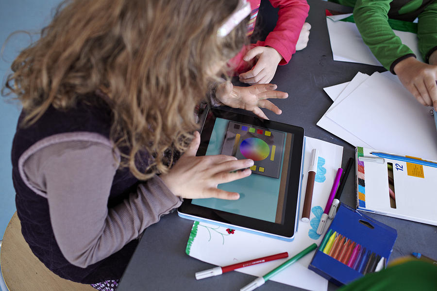 Girl drawing on tablet with classmates Photograph by Klaus Vedfelt