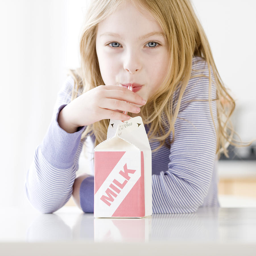 Girl drinking carton of milk Photograph by Tetra Images - Jamie Grill