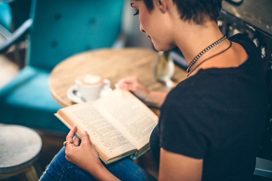Girl Drinking Coffee and Reading Book in Cafe Photograph by Eclipse_images