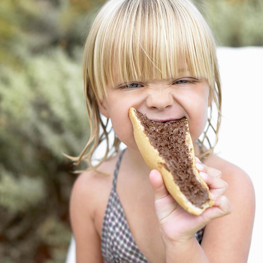 Girl eating a chocolate sandwich Photograph by Ghislain & Marie David de Lossy