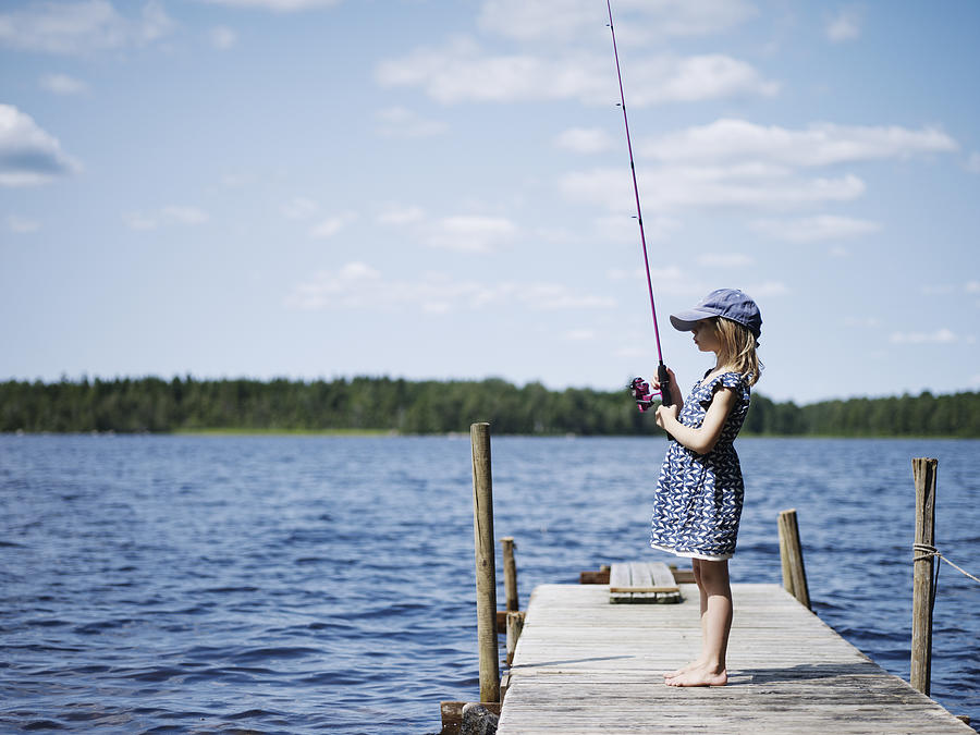 Girl fishing on jetty Photograph by Johner Images