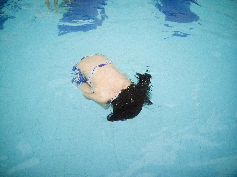 Girl floating on the pool Photograph by Minechika Endo