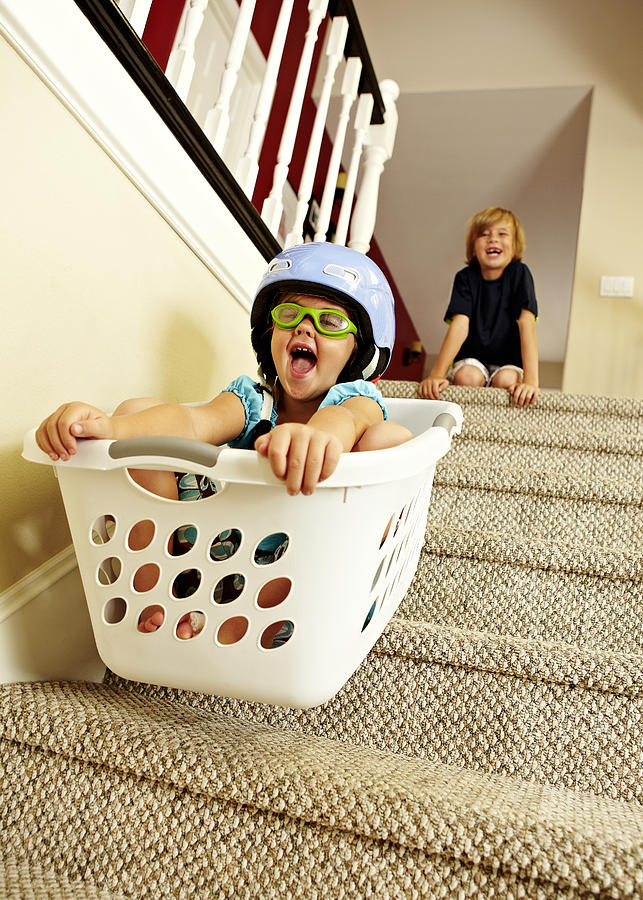 Girl going downstairs in a laundry basket. Photograph by Tony Garcia