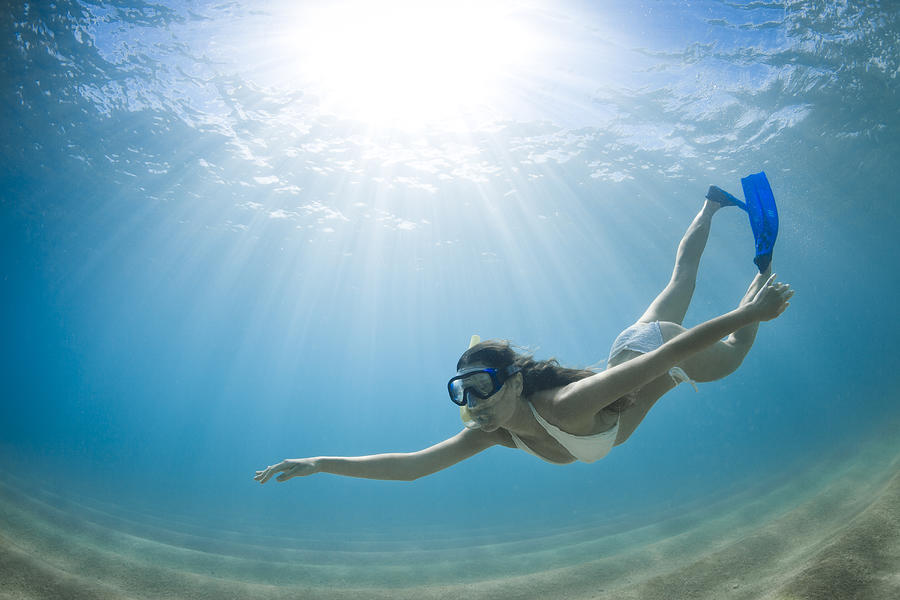 Girl gracefully free diving in clear water Photograph by Justin Lewis