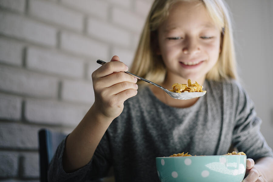 Girl having corn-flex for breakfast Photograph by Milanvirijevic