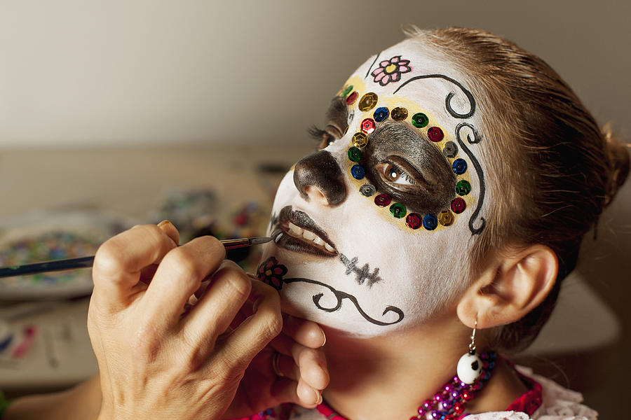 Girl having face painted for Dia de los Muertos Photograph by Sollina Images