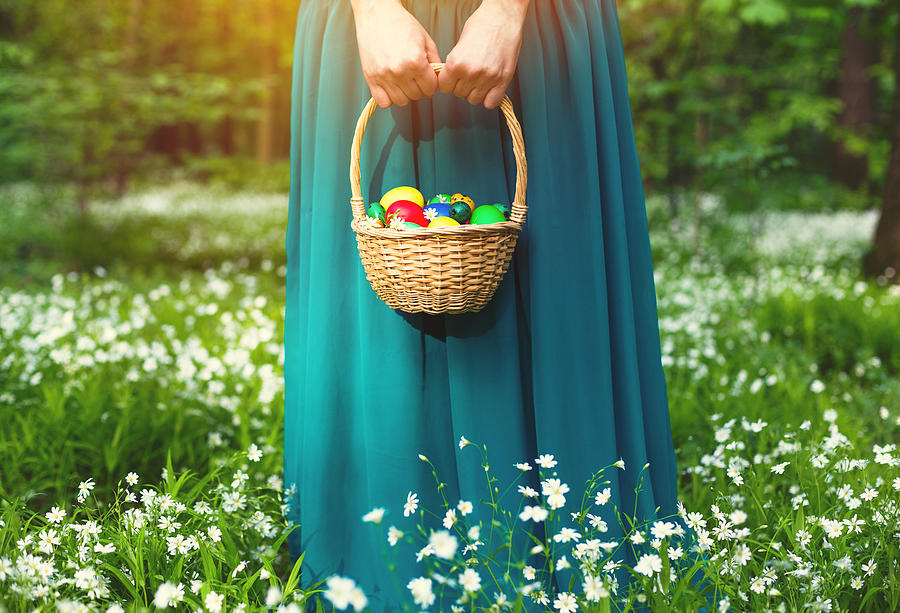 Girl holding Basket of easter eggs on meadow Photograph by Lkoimages