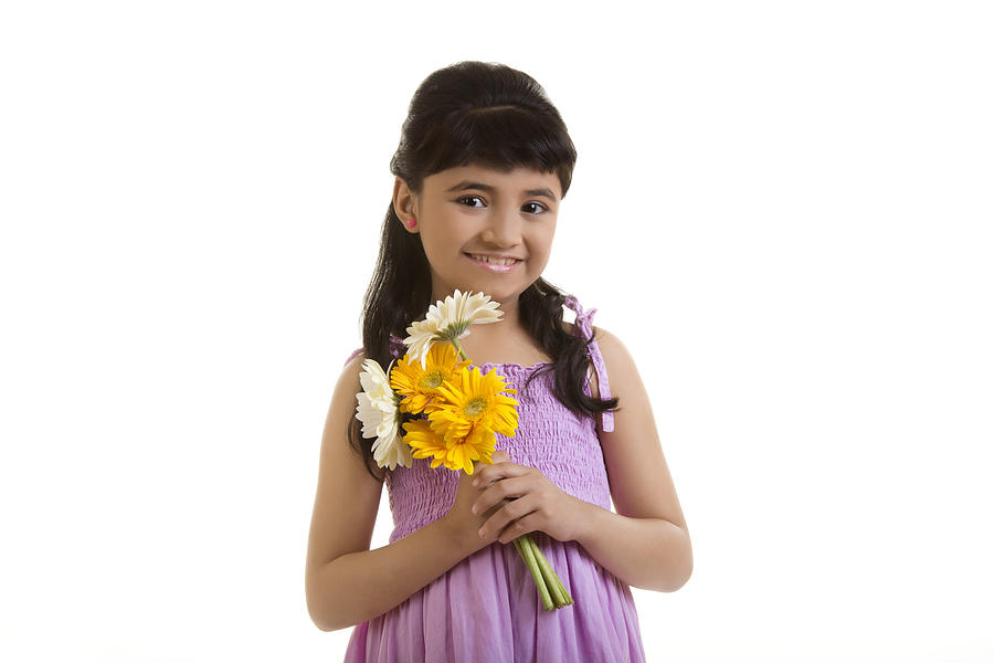 Girl holding flowers Photograph by IndiaPix/IndiaPicture