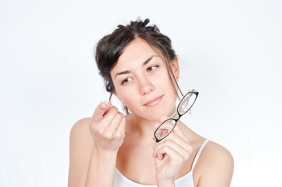 Girl holding glasses in one hand and contact lens other hand Photograph by Tderden