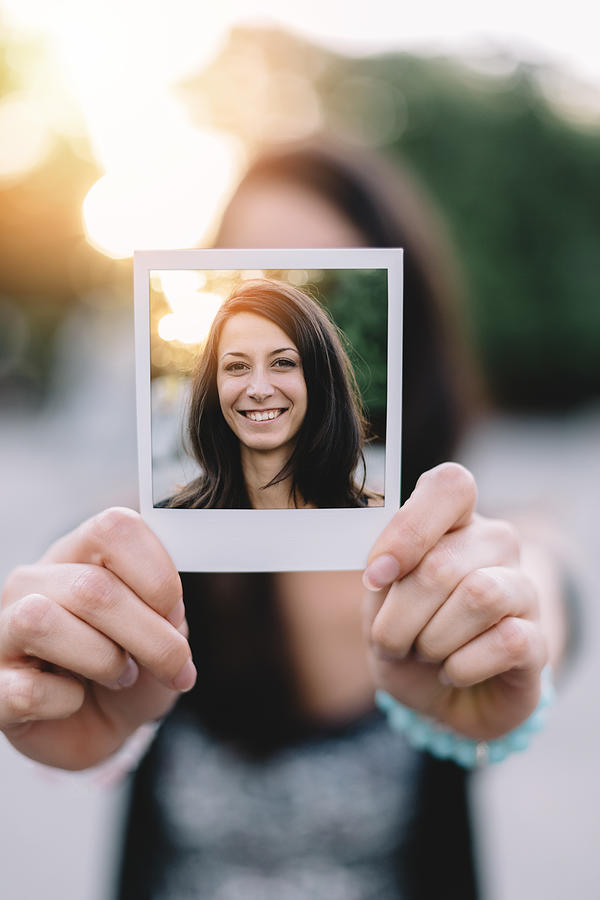 Girl holding instant photo selfie Photograph by Martin-dm