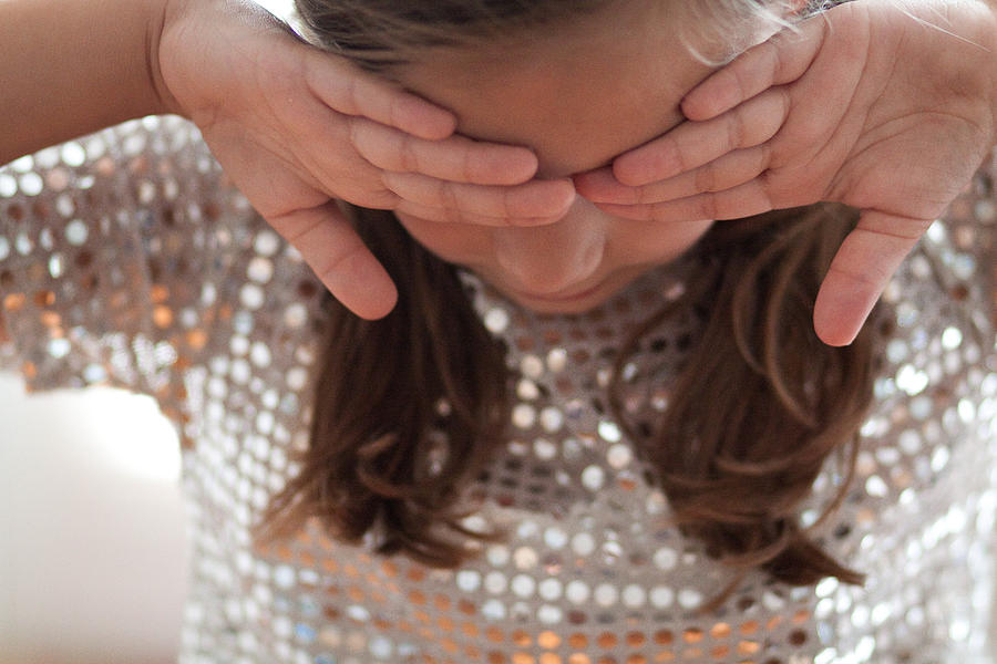 Girl in a sequin top covering eyes with backs of hands Photograph by Lamulligan