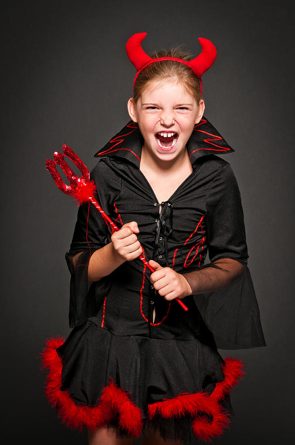 Girl in devil costume laughing and screaming, isolated on black Photograph by Domin_domin