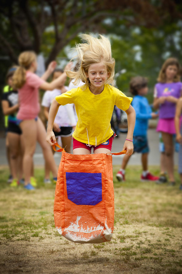 Girl Leaping On School Sack Race Photograph by Stephen Simpson