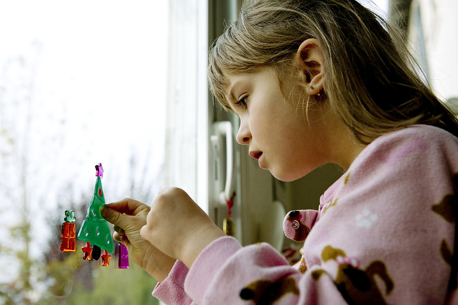 Girl making a toy Christmas tree on patio door Photograph by Geri Lavrov