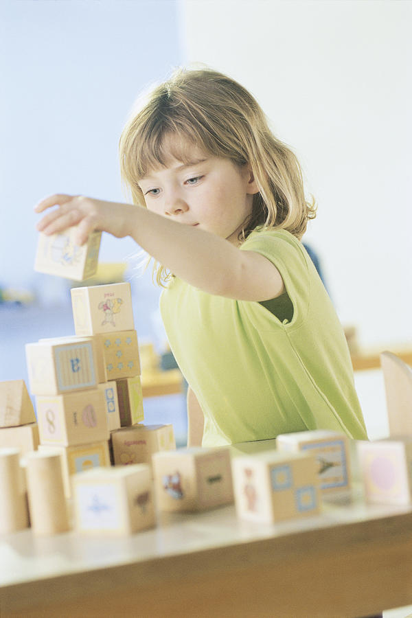 Girl playing with blocks Photograph by Comstock