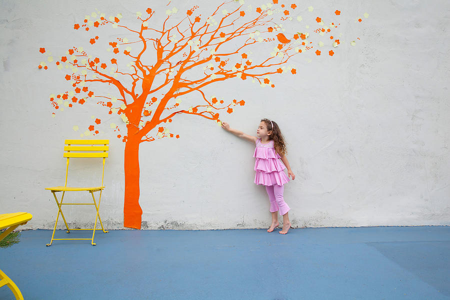 Girl pointing to orange tree mural on wall Photograph by David Jakle