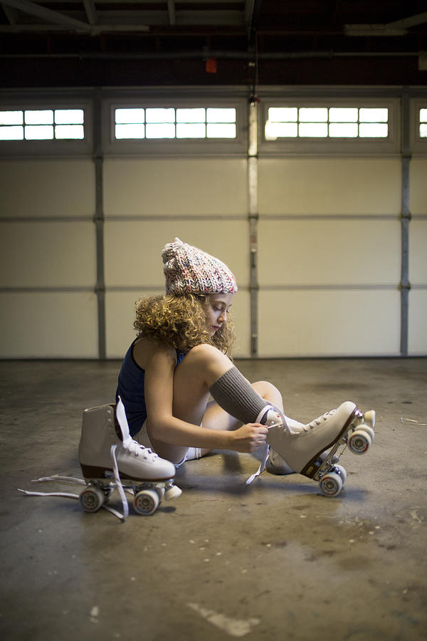 Girl putting on roller skates Photograph by Catherine Ledner