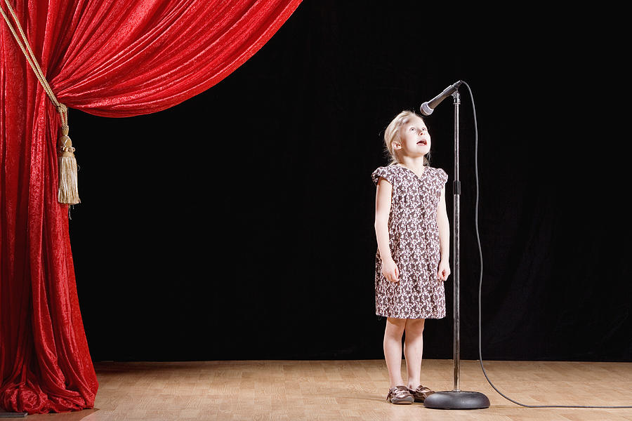 Girl speaking into microphone on stage Photograph by Terry Vine