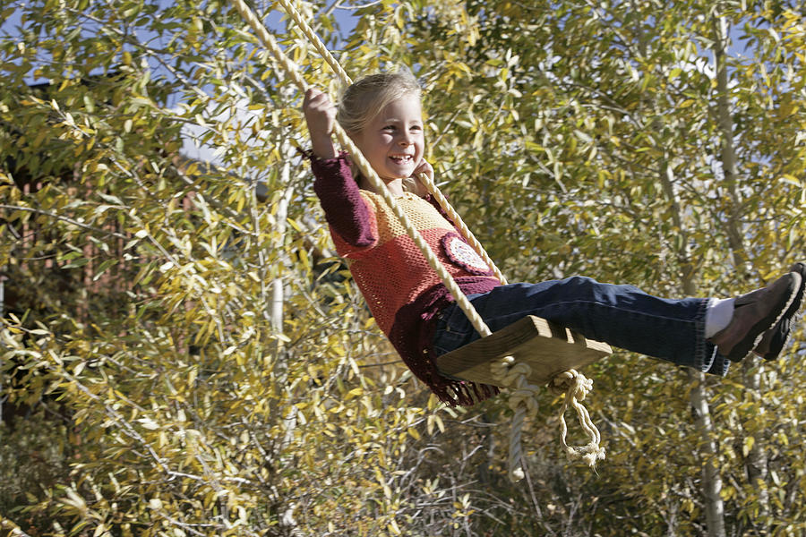 Girl swinging Photograph by Comstock Images
