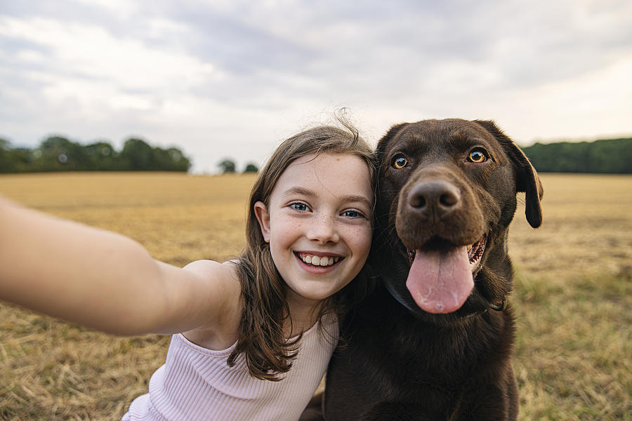 Girl taking a selfie with her pet dog Photograph by Justin Paget