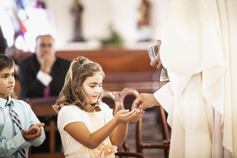 Girl taking her first communion at church Photograph by Sollina Images