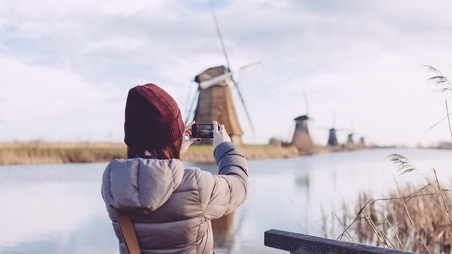 Girl taking picture of windmills with smartphone Photograph by Oscar Wong