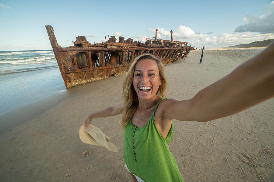 Girl traveling takes selfie portrait with Shipwreck on Fraser Island Photograph by Swissmediavision