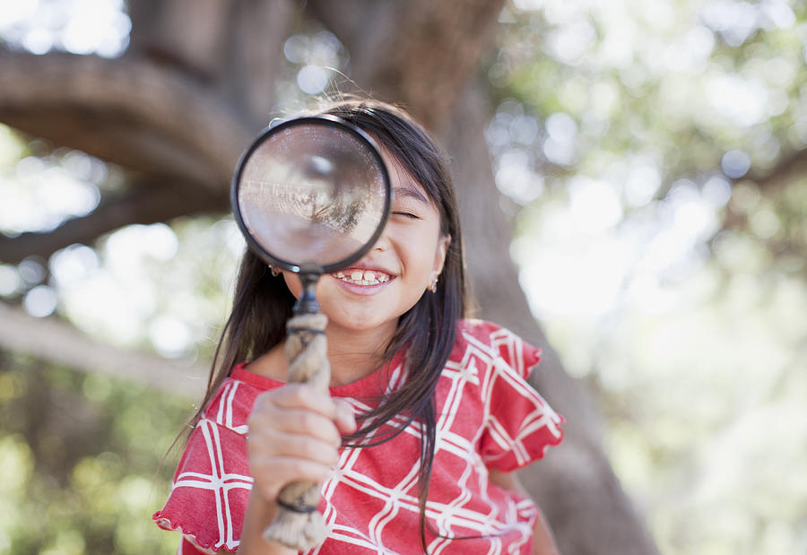 Girl using magnifying glass outdoors Photograph by Paul Bradbury Girl using magnifying glass outdoors Photograph by Paul Bradbury