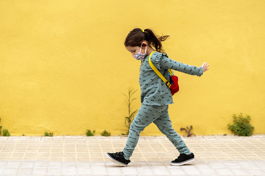 Girl Walking With Backpack And Mask Outdoors Photograph by Westend61