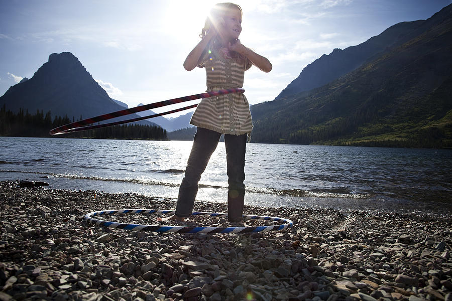 Girl with hula-hoops by lake. Photograph by Rebecca Drobis