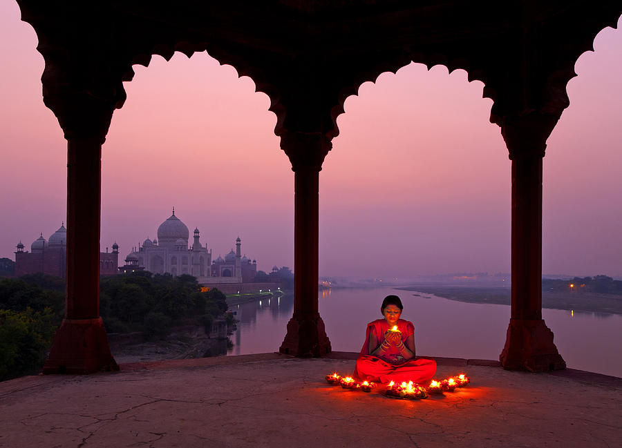 Girl with prayer lamp with Taj Mahal in background Photograph by Adrian Pope