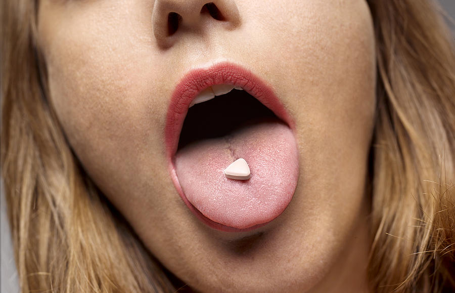 Girl with recreation drug on tongue Photograph by Peter Dazeley