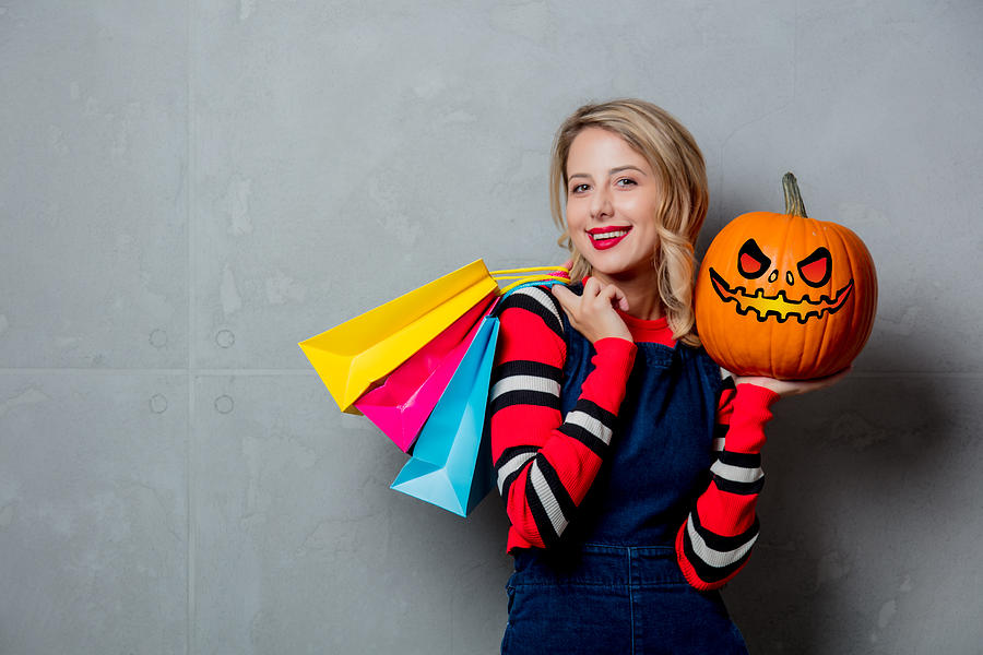 Girl With Shopping Bags And Halloween Pumpkin Photograph by Massonstock