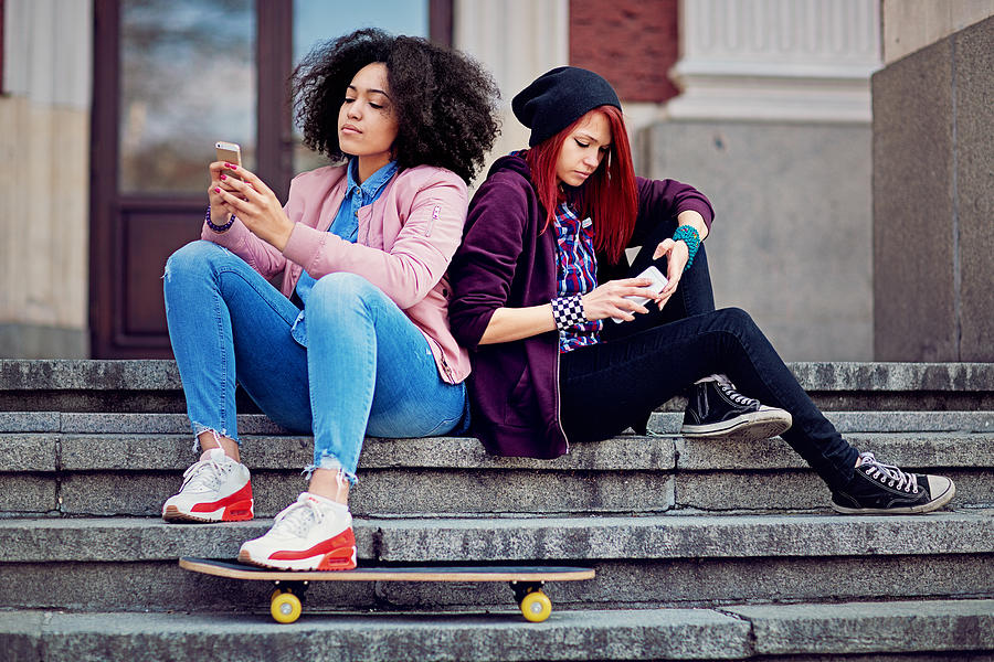 Girlfriends in conflict are texting and sulking each other Photograph by Praetorianphoto