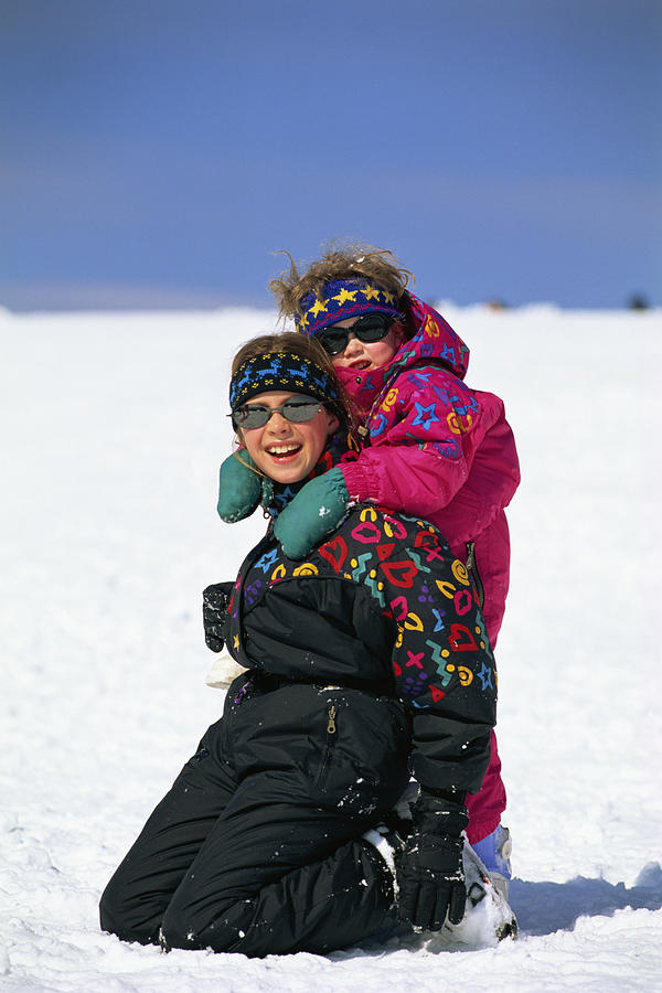 Girls playing in snow Photograph by Comstock Images