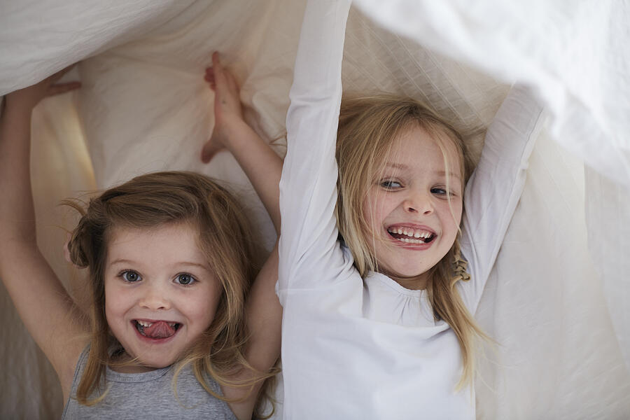 Girls playing under blanket Photograph by Sydney Bourne