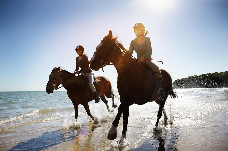 Girls riding horses on beach Photograph by Anthony Lee
