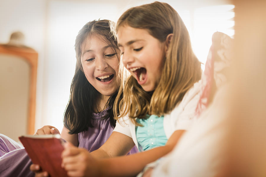 Girls using digital tablet together Photograph by Blend Images - Sollina Images