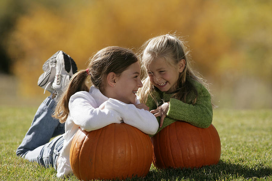 Girls with pumpkins Photograph by Comstock Images