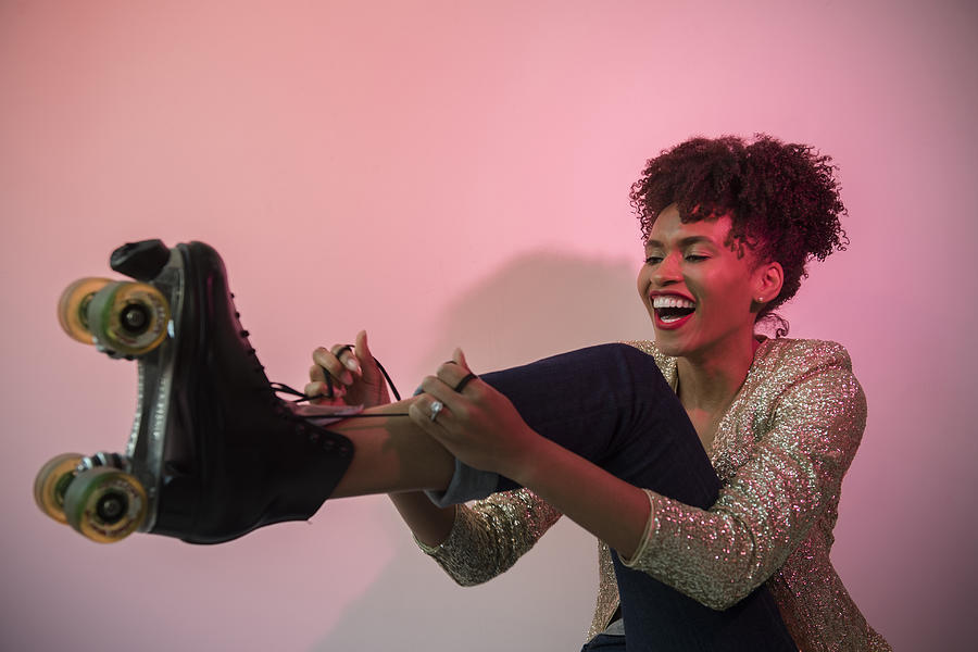 Glamorous Black woman tying roller skate Photograph by JGI/Jamie Grill