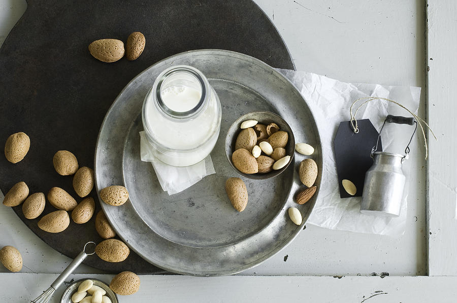 Glass bottle of homemade almond milk and almonds Photograph by Westend61