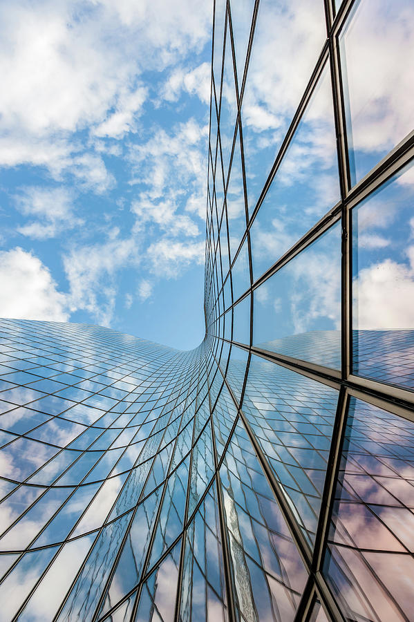 Glass curved building and blue sky Photograph by Philippe Lejeanvre