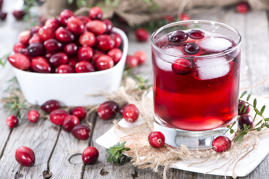 Glass of fresh cranberry juice and a bowl of cranberries Photograph by HandmadePictures