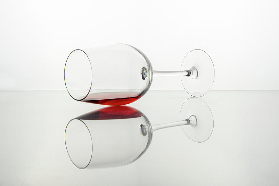 Glass of red wine on a transparent white surface Photograph by Michalakis Ppalis