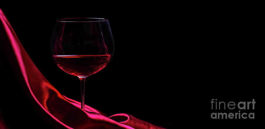 Glass Of Red Wine On Red Silk Against Black Background. Wine Lis Photograph