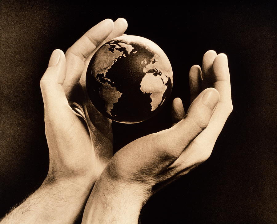 Globe floating between pair of mans hands (toned B&W) Photograph by Ray Massey
