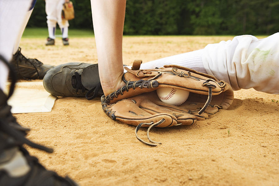 Glove of baseball player tagging runner out, maybe safe Photograph by Thinkstock