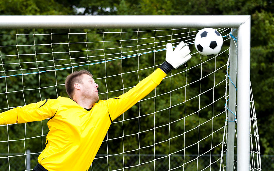 Goalkeeper tries to block perfect shot Photograph by Mikkelwilliam