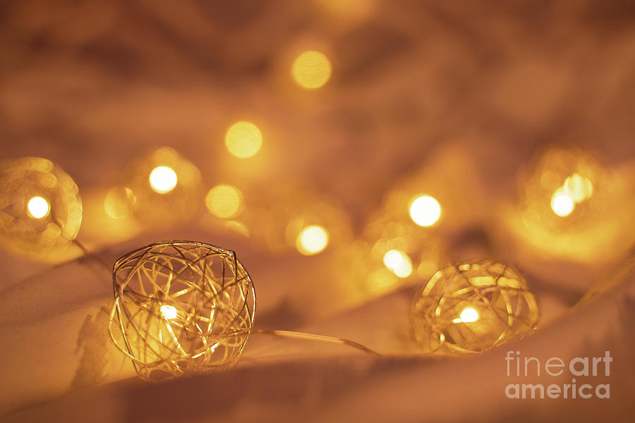 Golden blurred Christmas lights on rumpled bed sheets Photograph by Mendelex Photography