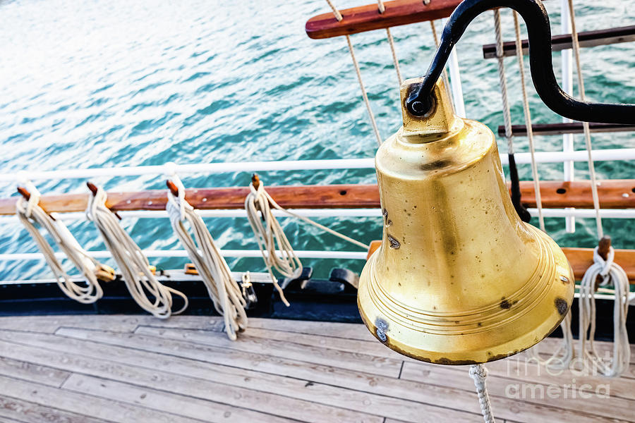 Golden bronze bell on the deck of a sailboat. Photograph by Joaquin Corbalan
